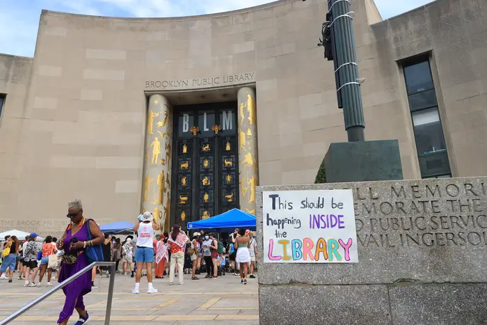 With protests gathered outside the Brooklyn Public Library, a says "this should be happening INSIDE the library."